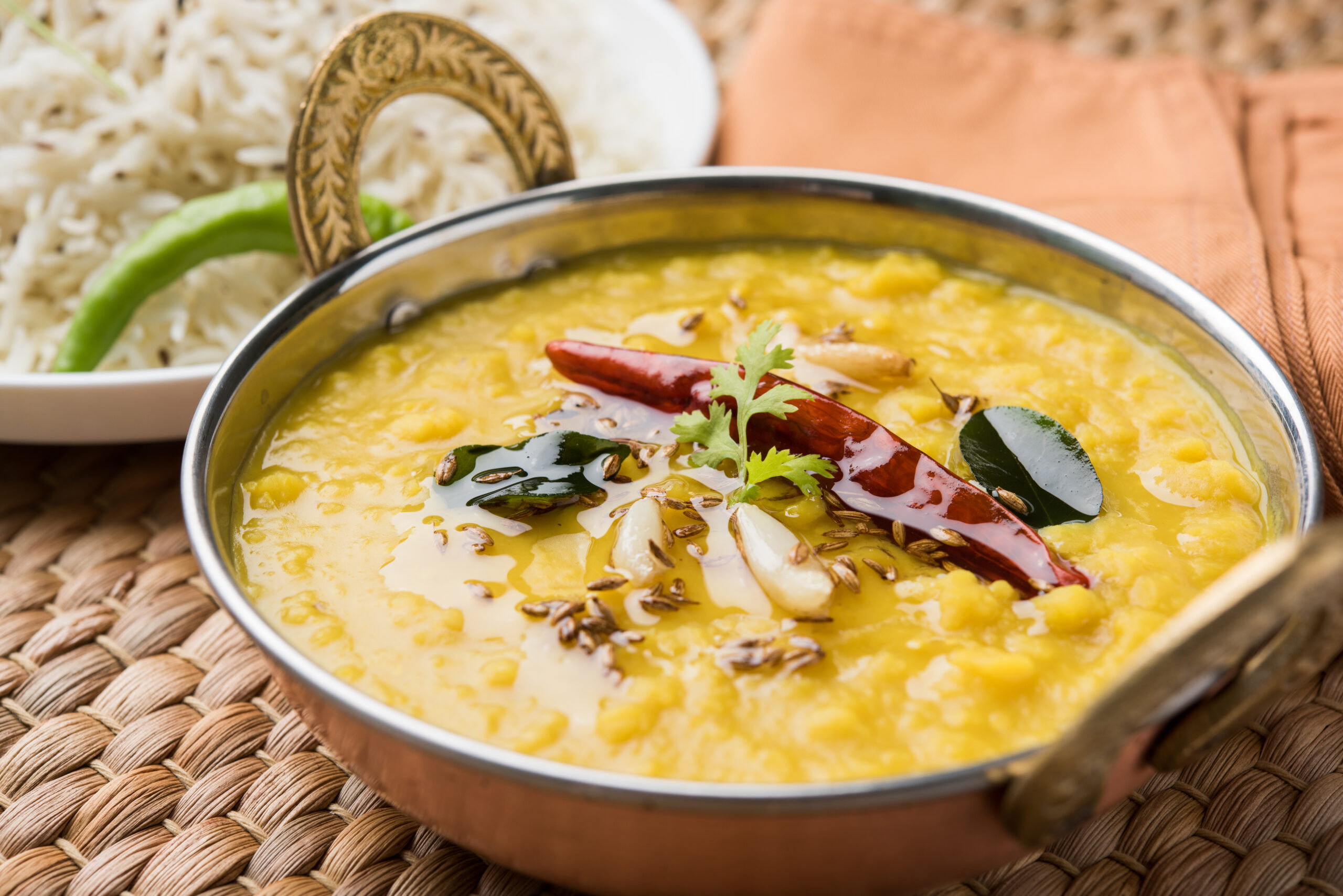 indian popular food dal fry or traditional dal tadka curry served with jeera rice, isolated over white background, selective focus