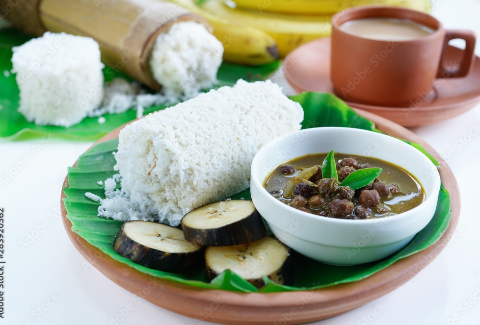 kerala breakfast rice puttu made in bamboo mould served with kadala curry banana papad