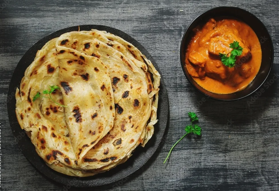 homemade kerala wheat paratha or layered parotta served with paneer curry