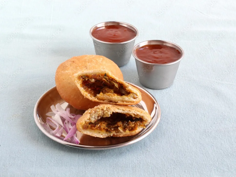 kachori, a delicious and an indian vegetarian deep fried dish, with its shell made from flour dough and filled with items like chopped onion, red chili powder, and cumin seeds