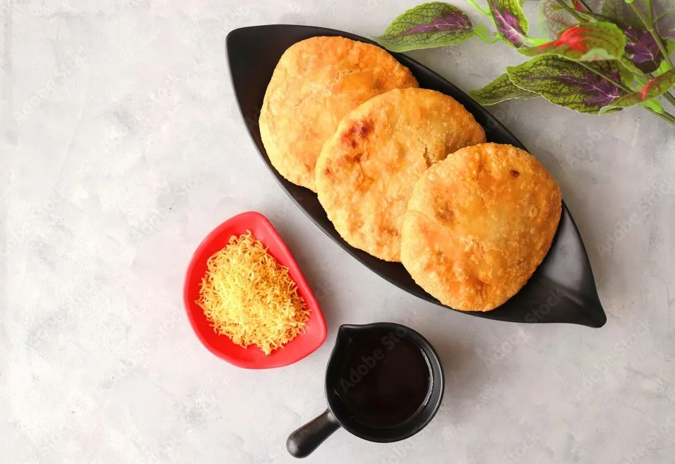 baked kachori served with tamarind chutney and sev.