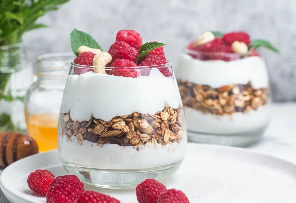 granola with yogurt and raspberries in a glass