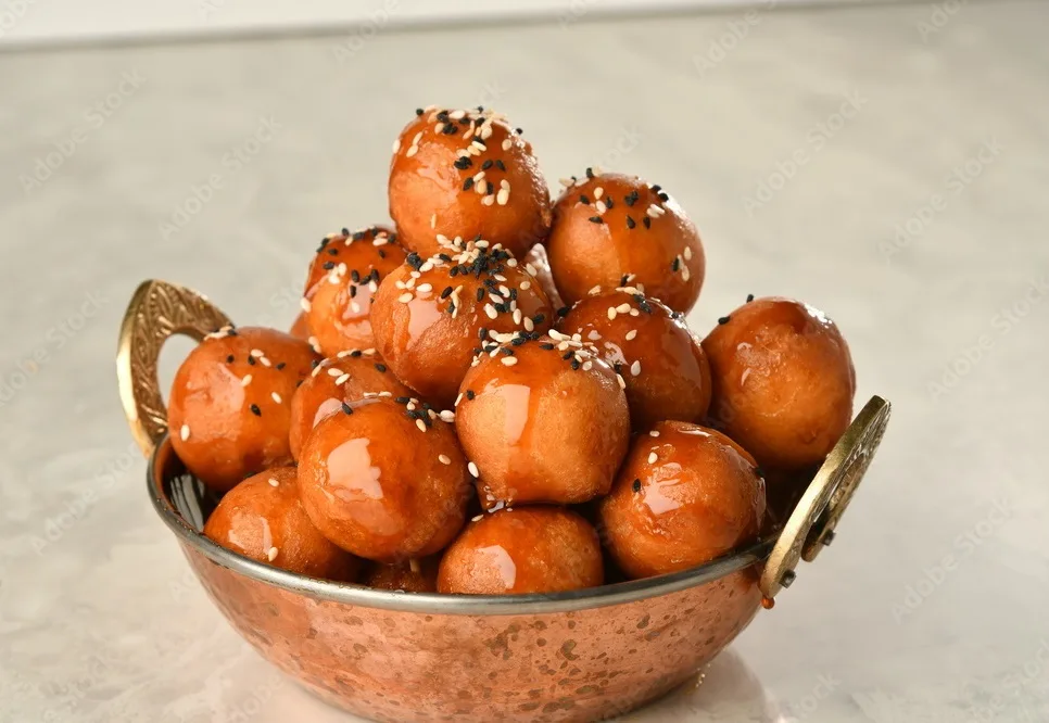 luqaimat or lokma. freshly fried lokma piled high a popular middle eastern dessert of small dough balls deep fried then coated in sugar or honey